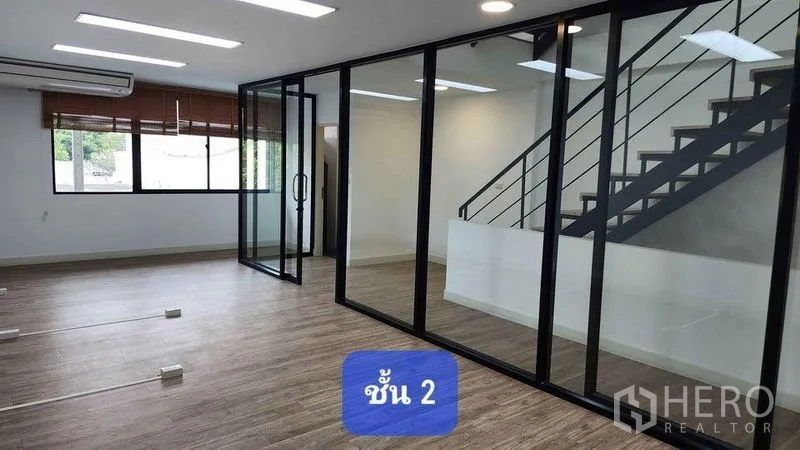 Townhouse for rent in Bueng Kum, Bangkok - Glass-partitioned office zone with staircase, wide windows and air conditioning.
