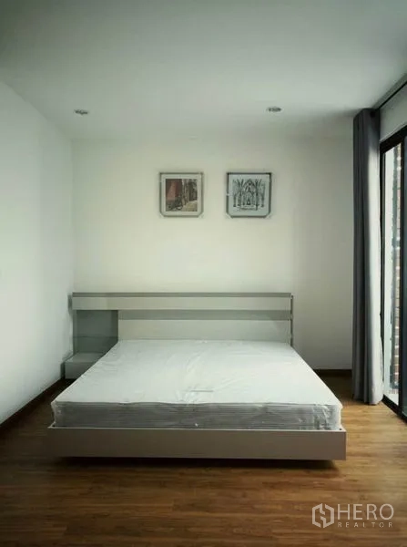 Townhouse for rent in Suan Luang, Bangkok - Minimal master bedroom with platform bed and a door to the balcony.