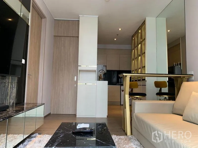 Condominium for sale - Cozy lounge with sofa, mirrored dining bar and city-view windows leading to kitchen.