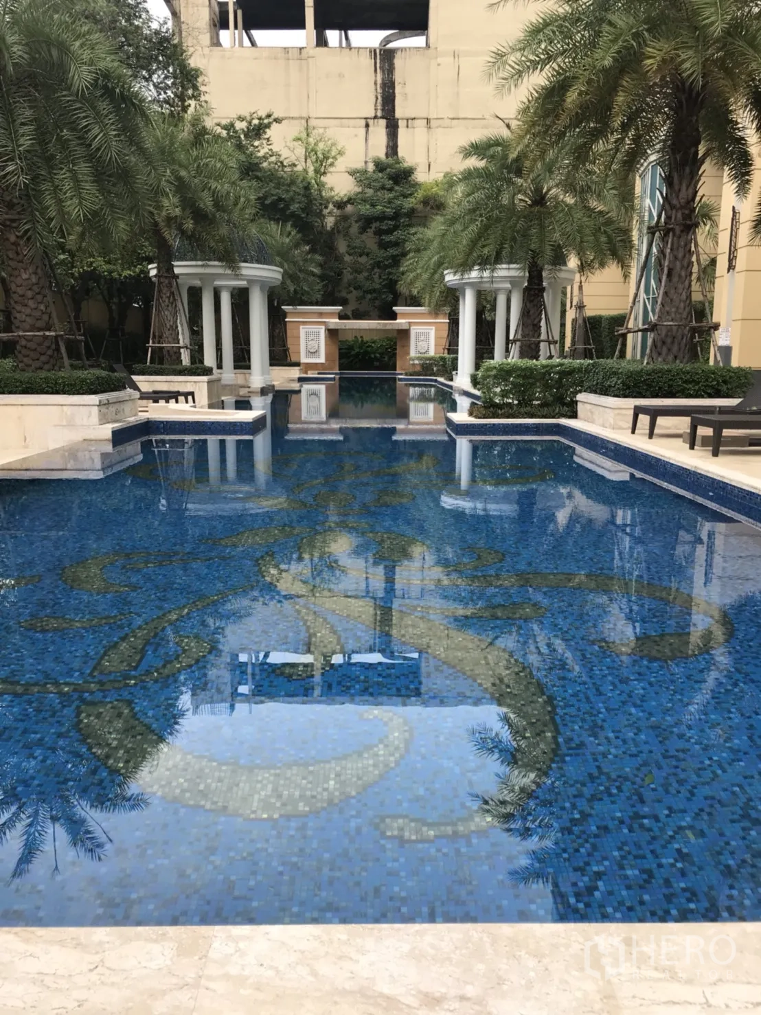 公寓 出租在Watthana, Bangkok - 度假风泳池，蓝色马赛克池底、棕榈树与凉亭。