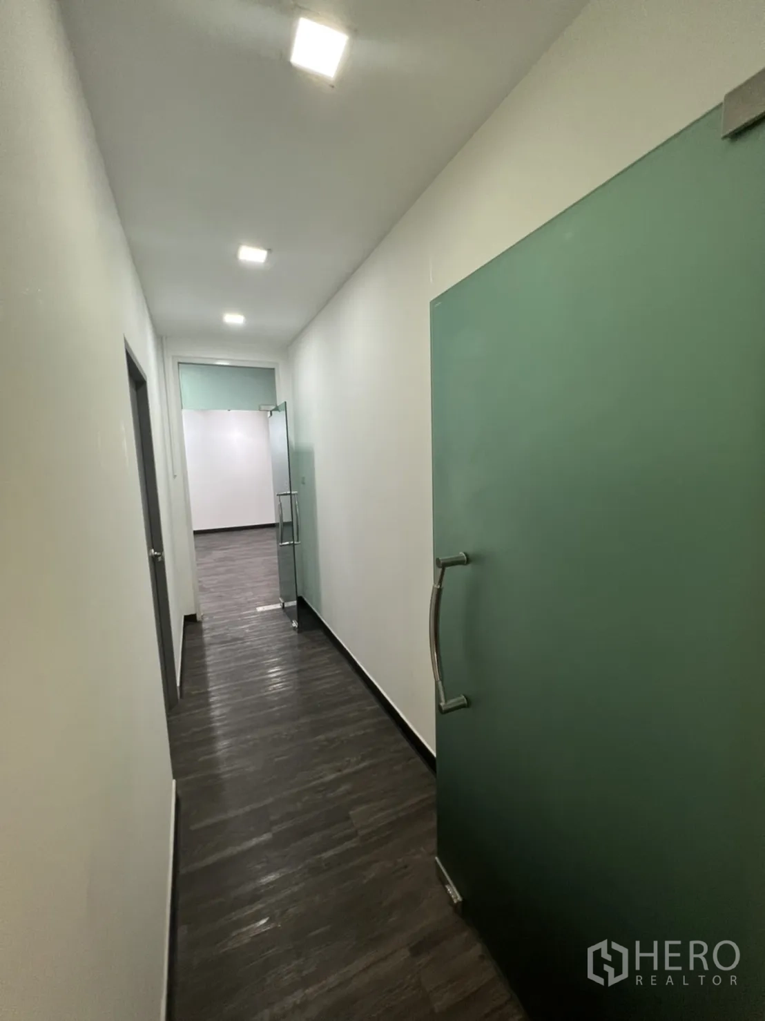 Retail Space for rent in Sathon, Bangkok - Hallway with matte green glass doors and downlights.