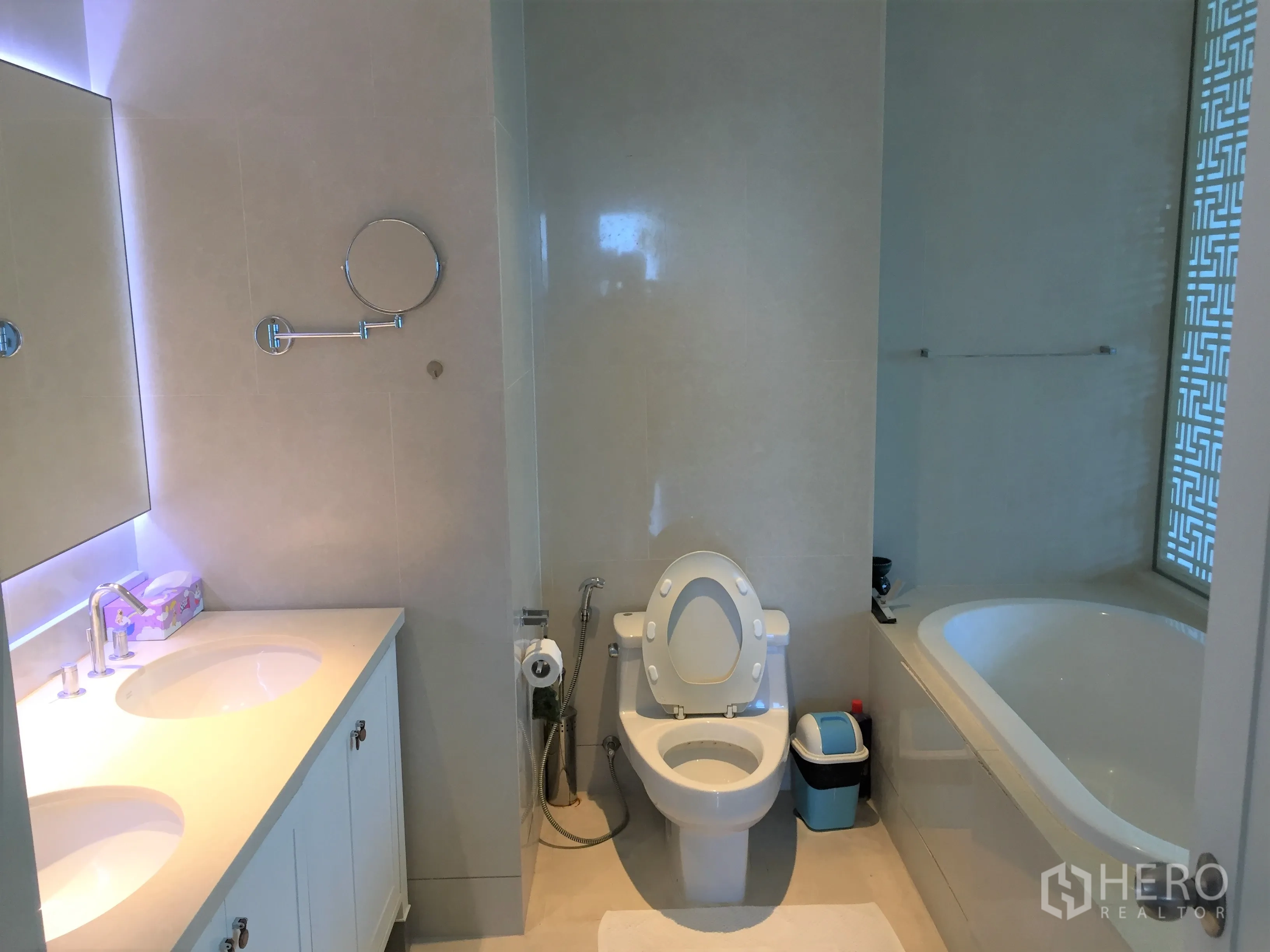 Condominium for rent or sale in Khlong Toei, Bangkok - Modern bathroom featuring a double-sink vanity, toilet and a large soaking bathtub.