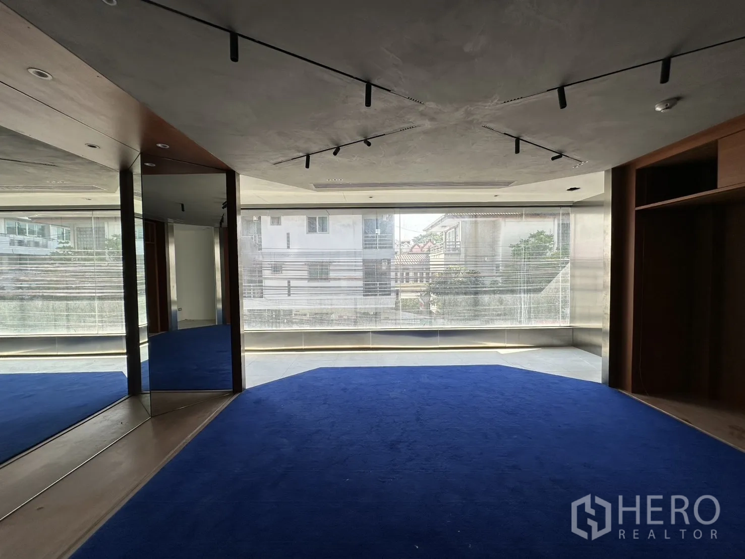พื้นที่ขายของ for rent in Watthana, Bangkok - พื้นที่ชั้นบนมีหน้าต่างบานกว้าง พรมสีน้ำเงิน และไฟรางบนเพดาน.