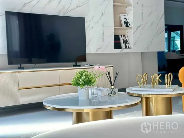 Detached House for rent or sale in Bang Phli, Samut Prakan - Modern living area with marble TV wall, sleek media console and round gold-base coffee tables.