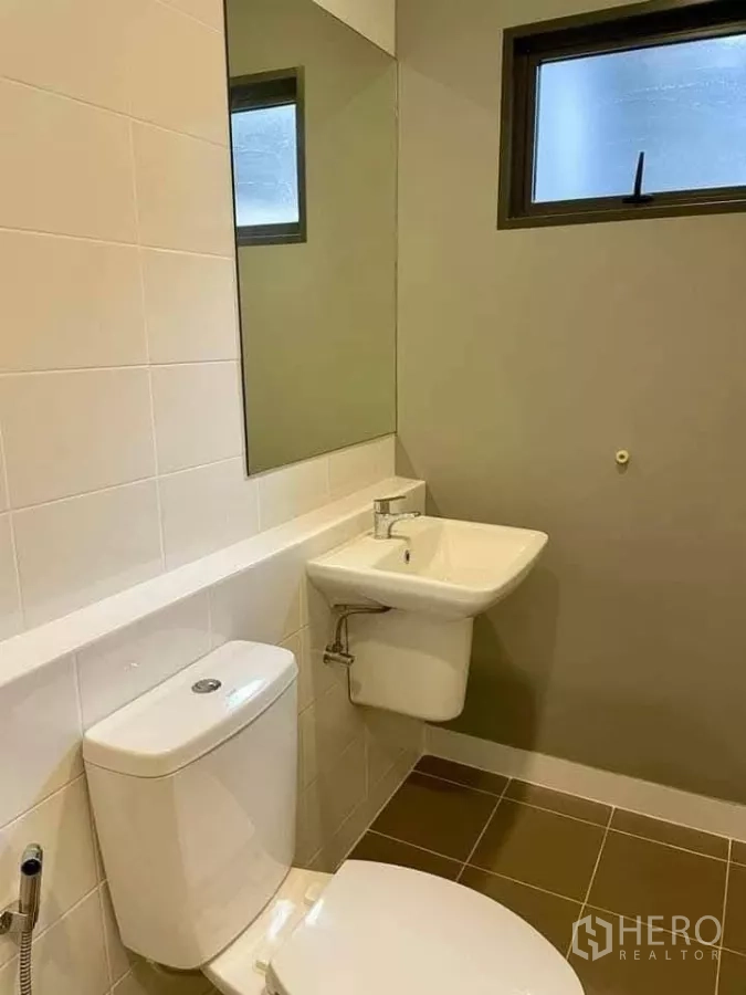 联排别墅 出租在Bang Phli, Samut Prakan - 整洁浴室，坐便器、洗手盆、大镜子与磨砂窗