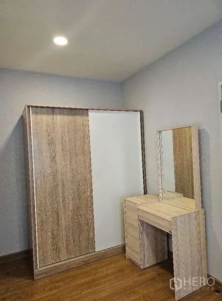 Detached House for rent in Bang Phli, Samut Prakan - Bedroom corner with wooden wardrobe and matching dressing table on wood flooring.