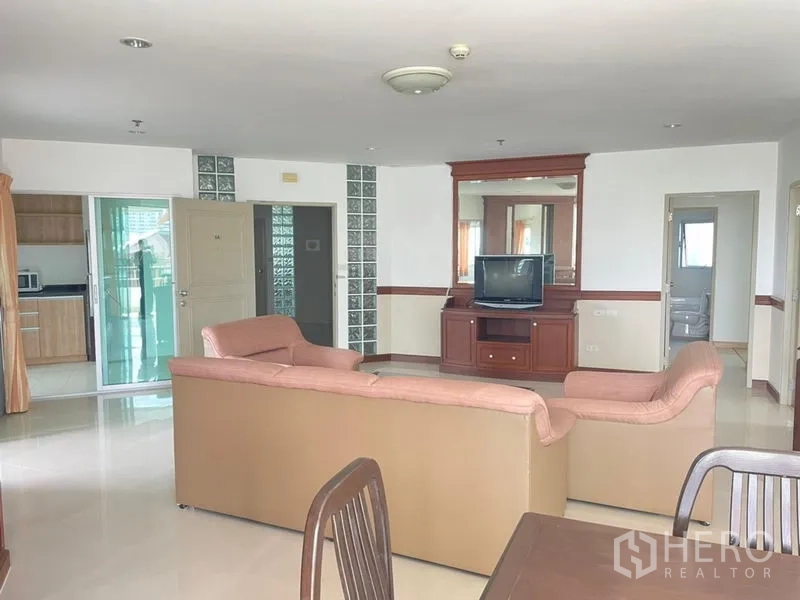 Condominium for rent in Khlong Toei, Bangkok - Wide lounge and dining space with sliding door to the kitchen and balcony access.