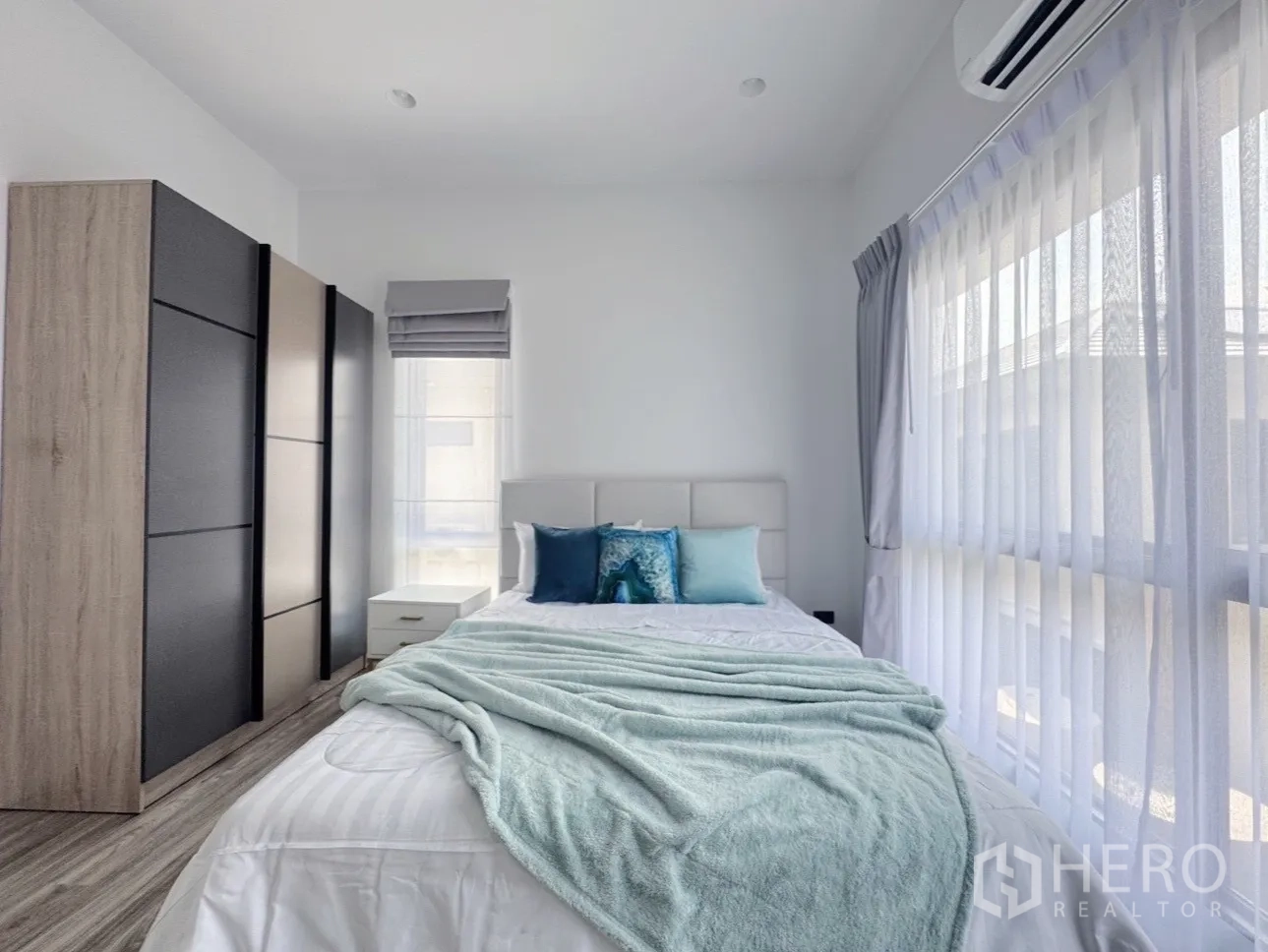 Detached House for rent or sale in Bang Kapi, Bangkok - Second bedroom showing wardrobes, bedside table and wide glazing.