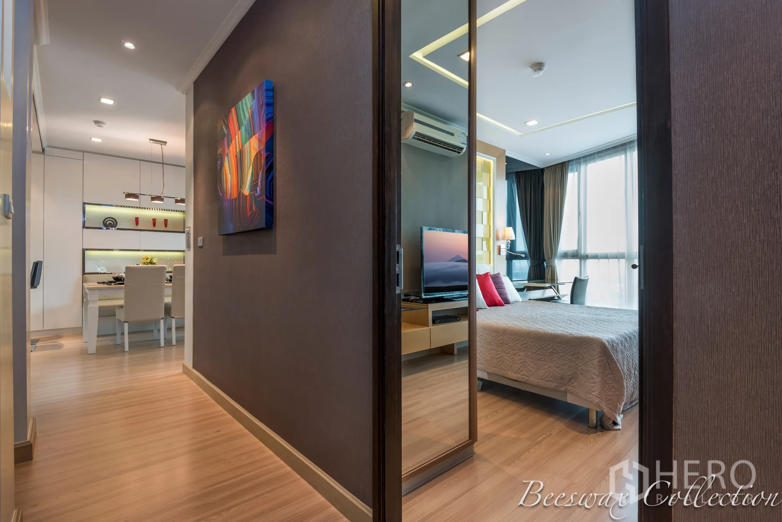 Condominium for rent in Watthana, Bangkok - Bright corridor linking dining area and bedroom with wood floors and a mirrored wardrobe.