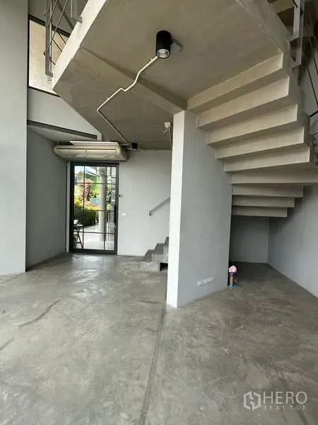 带办公室的家 出租或出售在Prawet, Bangkok - 双层挑高大堂，外露混凝土楼梯与抛光地面。
