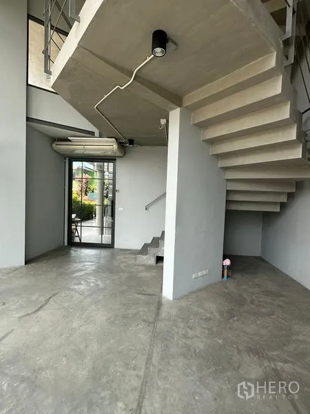 带办公室的家 出租或出售在Prawet, Bangkok - 双层挑高大堂，外露混凝土楼梯与抛光地面。