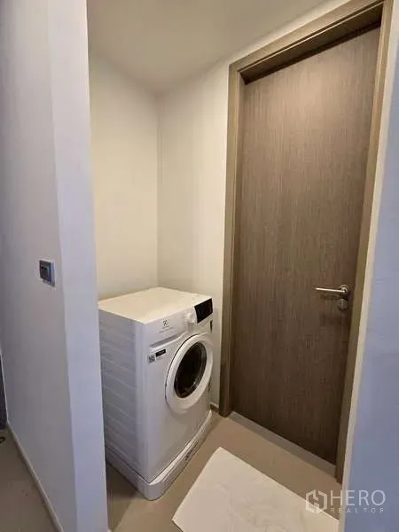 公寓 出租在Phaya Thai, Bangkok - 紧凑洗衣角，放置前置式洗衣机，邻近木门。