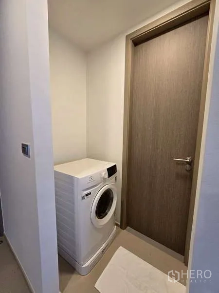 公寓 出租在Phaya Thai, Bangkok - 紧凑洗衣角，放置前置式洗衣机，邻近木门。