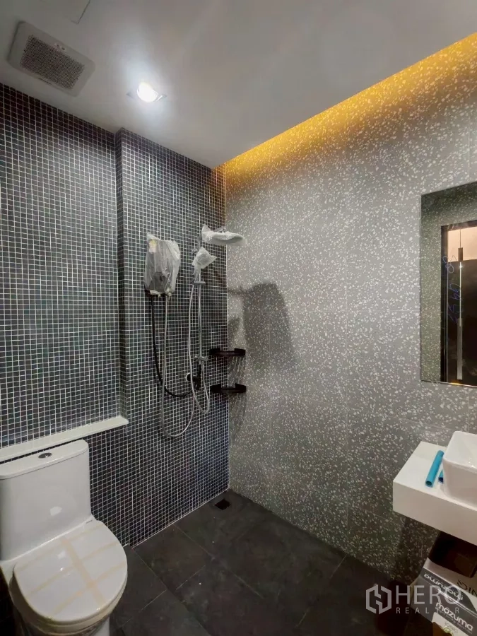 Detached House for rent in Wang Thonglang, Bangkok - Bathroom with gray terrazzo-style wall, mosaic tiles, and shower set.