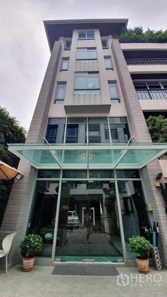 办公空间 出租在Khlong Toei, Bangkok - 现代中高层建筑入口，带玻璃雨棚的外立面