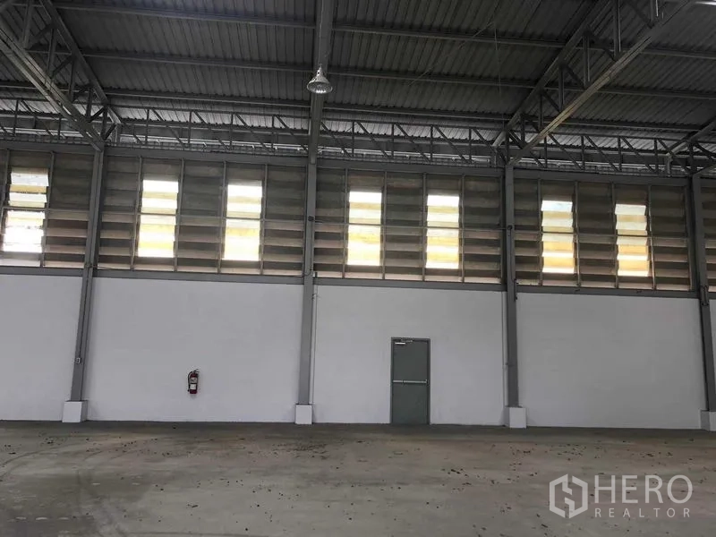 货栈 出租在Prawet, Bangkok - 仓库内部高挑空间，钢桁架、天窗与百叶采光，混凝土地面