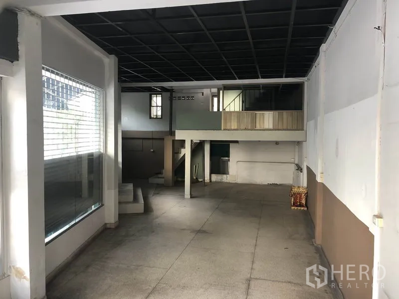 Retail Space for rent in Khlong Toei, Bangkok - Open-plan retail interior with high ceiling, mezzanine level, and large display window.