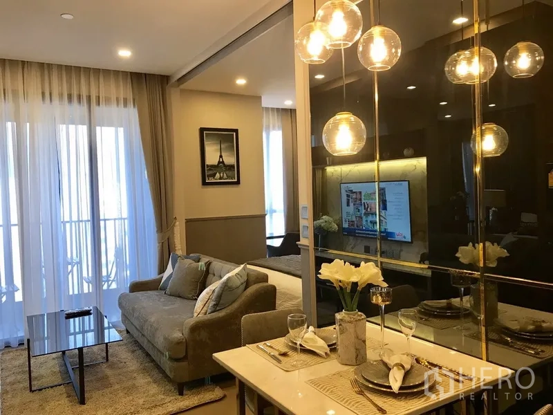 Condominium for rent in Watthana, Bangkok - Open-plan living and dining area with floor-to-ceiling curtains and a mirrored wall.