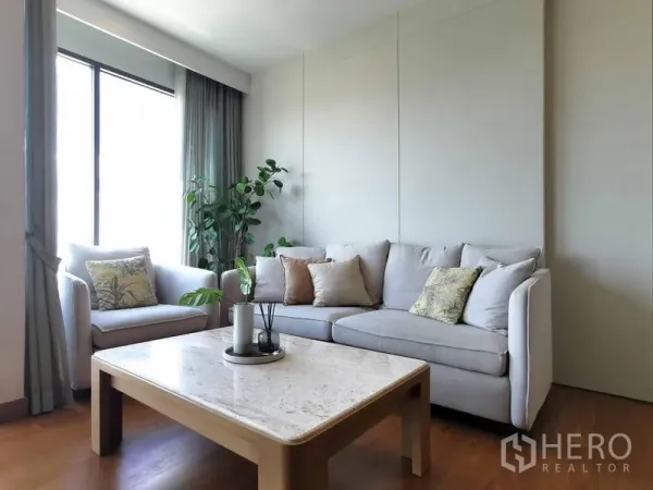 Condominium for rent in Sathon, Bangkok - Cozy secondary lounge with natural light, curtains and a marble-top coffee table.