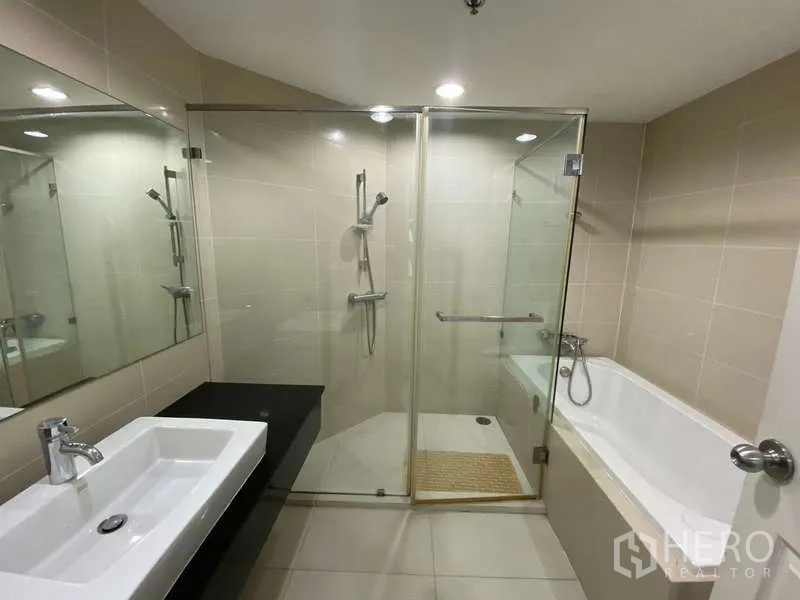 คอนโด for ในHuai Khwang, Bangkok - ห้องน้ำมีโซนอาบน้ำกระจกแยกกับอ่างอาบน้ำ กระจกบานยาวและอ่างล้างหน้าแบบสี่เหลี่ยม