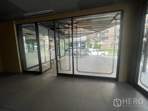 零售空间 出租在Khlong Toei, Bangkok - 室内朝入口视角，可见玻璃门与外部带顶平台。