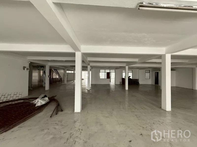 Shophouse for rent - Wide white hall with multiple columns and smooth flooring.