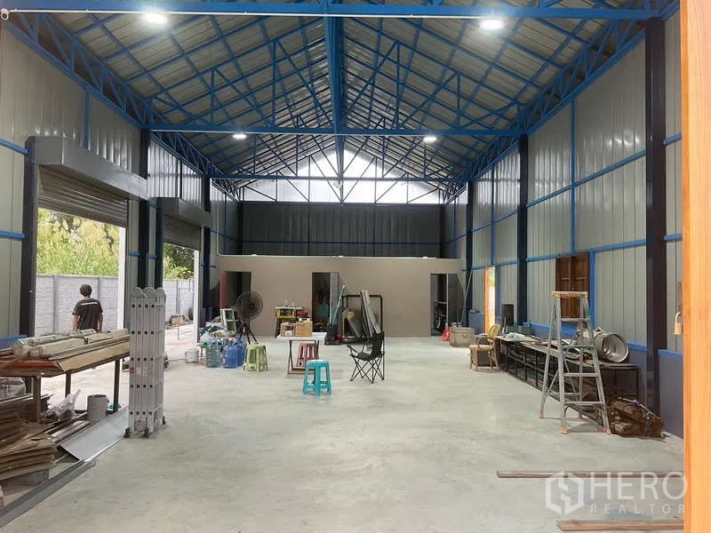 货栈 出租或出售在Nong Chok, Bangkok - 仓库内部挑高空间，蓝色钢桁架与天窗，约150平方米开放作业区。