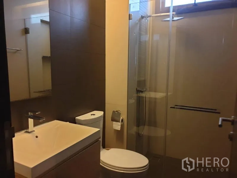 独立式住宅 出售在Watthana, Bangkok - 现代浴室，玻璃淋浴间、盥洗台与坐便器。