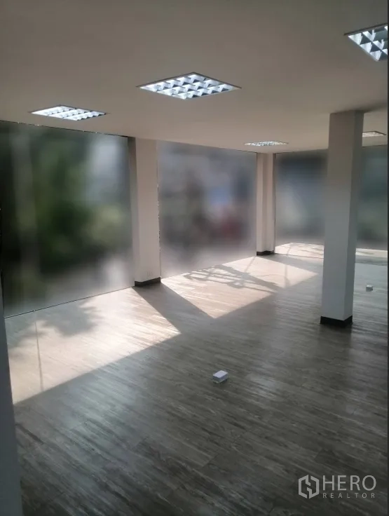零售空间 出租在Watthana, Bangkok - 开放式办公区，整面磨砂玻璃窗与木纹地板。