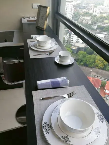 Condominium for sale - Close-up of the breakfast counter set for two beside a large window with expansive city views.