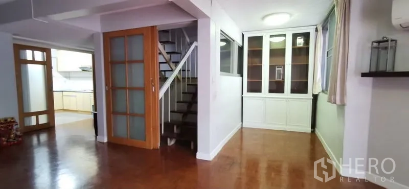 联排别墅 出租在Watthana, Bangkok - 开放式客餐厅，真皮沙发、吊灯与木地板