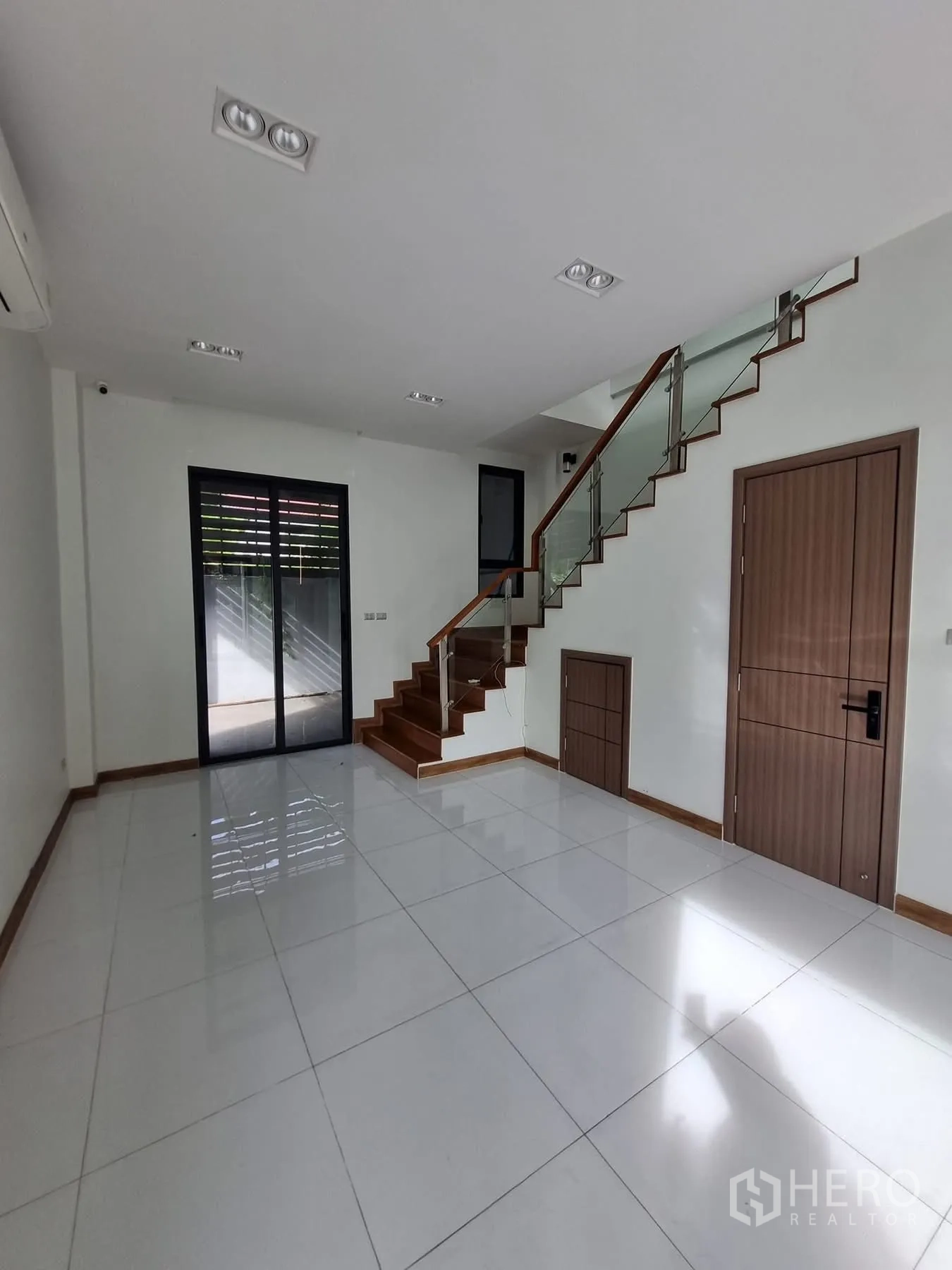Home Office for rent in Khlong Toei, Bangkok - Open tiled room with staircase and sliding door to the side yard.