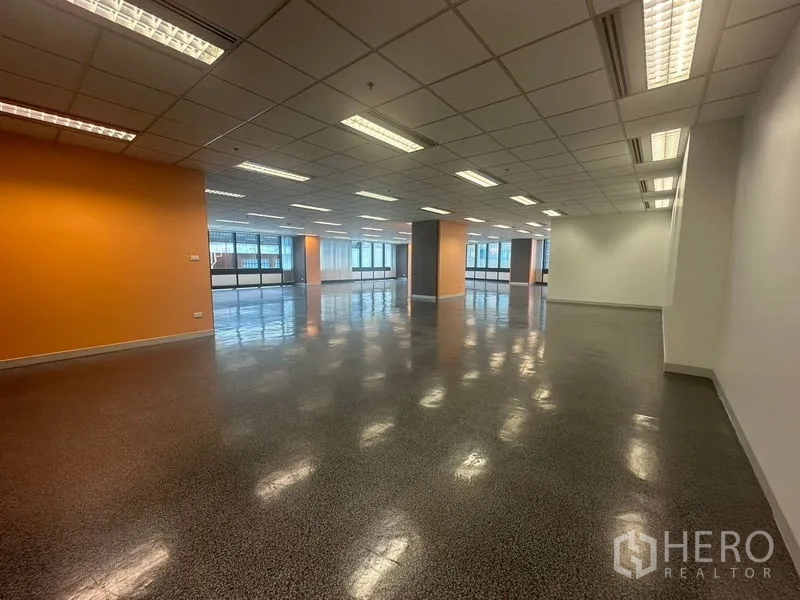 Office Space for rent in Khlong Toei, Bangkok - Expansive open-plan office floor with orange accent walls and ceiling lights.
