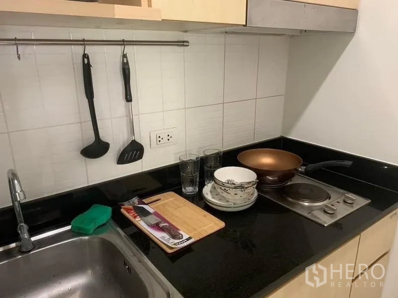 公寓 出租或出售 - 厨房台面特写，水槽、电炉与烹饪工具。