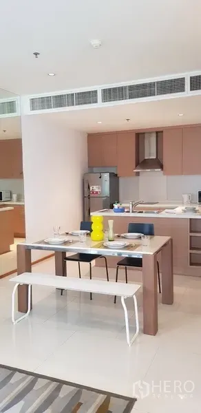 公寓 出租在Khlong Toei, Bangkok - 开放式餐区与现代厨房相连，配橱柜和不锈钢冰箱。