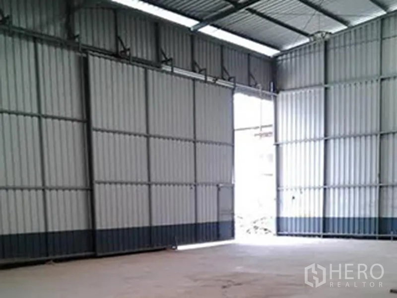 Warehouse for rent in Sai Mai, Bangkok - Spacious warehouse interior with high steel truss roof, wide sliding doors and durable concrete floor.