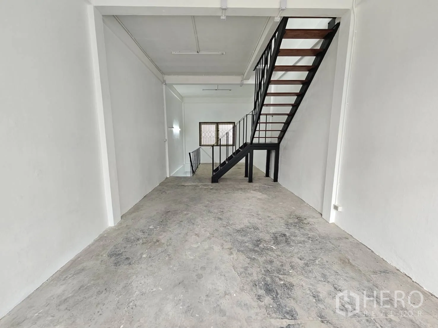 Home Office for rent in Khlong Toei, Bangkok - Open-plan level with concrete floor and central steel stairs.