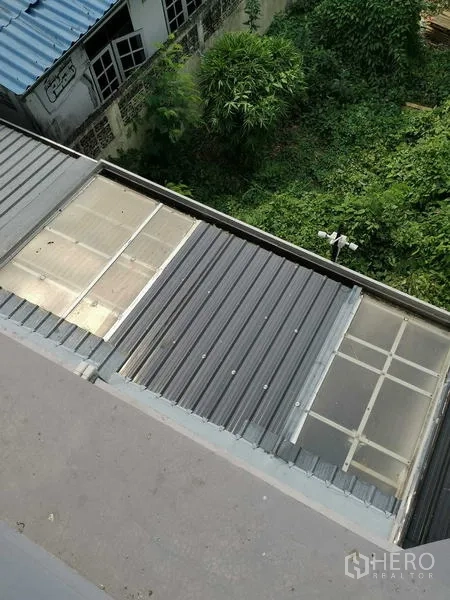 带办公室的家 出租或出售 - 俯视金属与半透明顶棚，覆盖服务区。