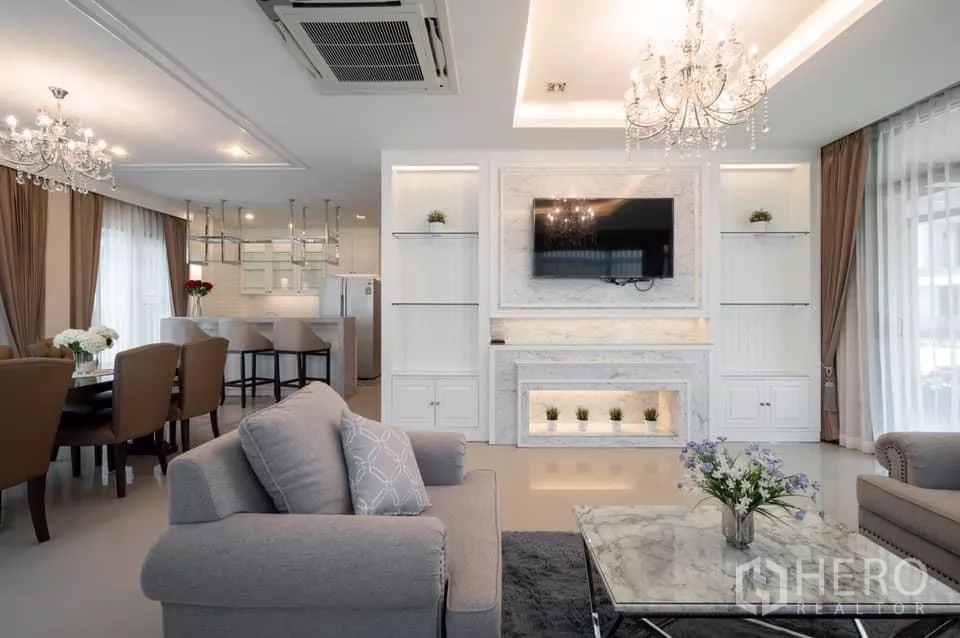 Detached House for rent in Prawet, Bangkok - Spacious lounge with chandelier lighting, marble feature wall and sheer curtains.