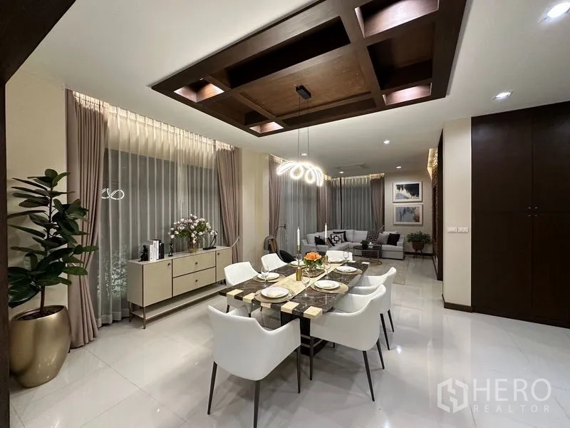 Detached House for rent - Elegant dining room with a marble-top table, eight white chairs and a sculptural chandelier.