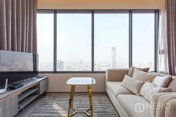 คอนโด ให้เช่าในWatthana, Bangkok - โซฟาและทีวีข้างหน้าต่างเต็มผนัง โต๊ะกลางหินอ่อนขนาดเล็ก พร้อมวิวเมืองแบบพาโนรามา