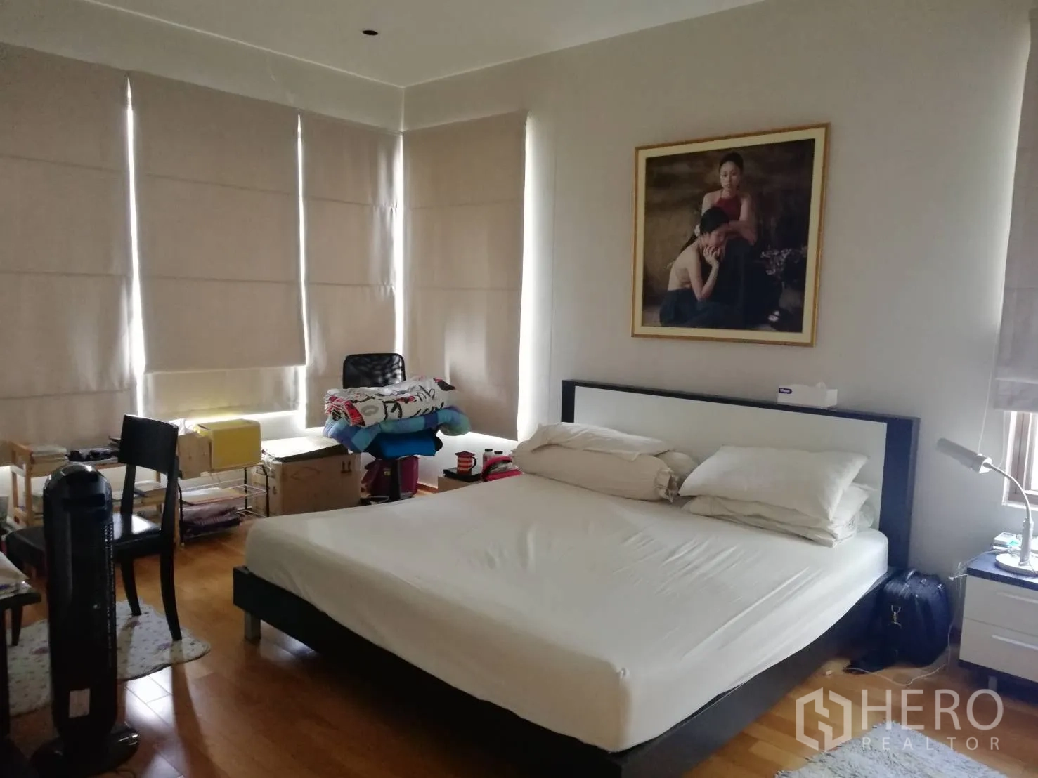 Condominium for sale in Khlong Toei, Bangkok - Primary bedroom with king bed, blackout blinds, wood floors and framed art.
