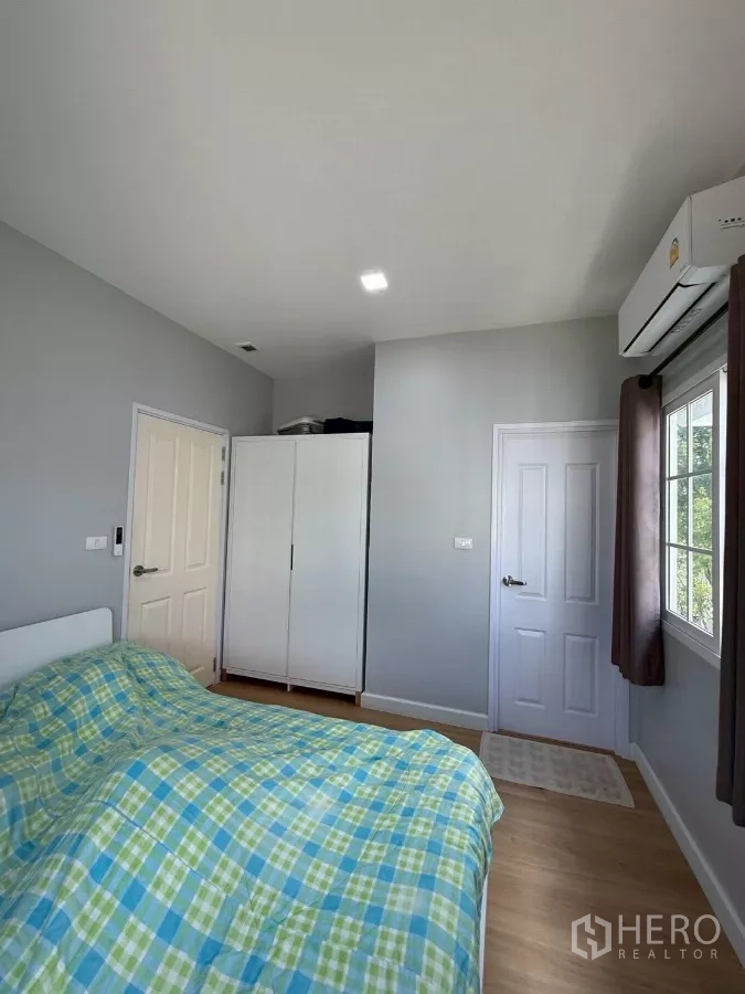 Detached House for rent in Bang Phli, Samut Prakan - Guest bedroom with air-conditioner, freestanding wardrobe and large window.