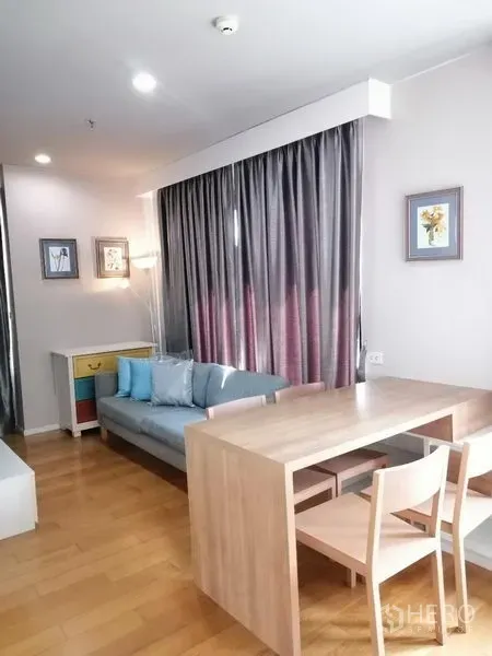 Condominium for rent in Watthana, Bangkok - Bright living and dining area with wood floors, gray curtains and sofa in an On Nut condo, Watthana Bangkok