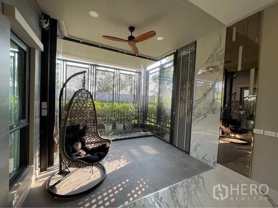 独栋房屋 for rent or sale in Bang Phli, Samut Prakan - 封闭式露台/日光房，吊椅与吊扇，绿景环绕。