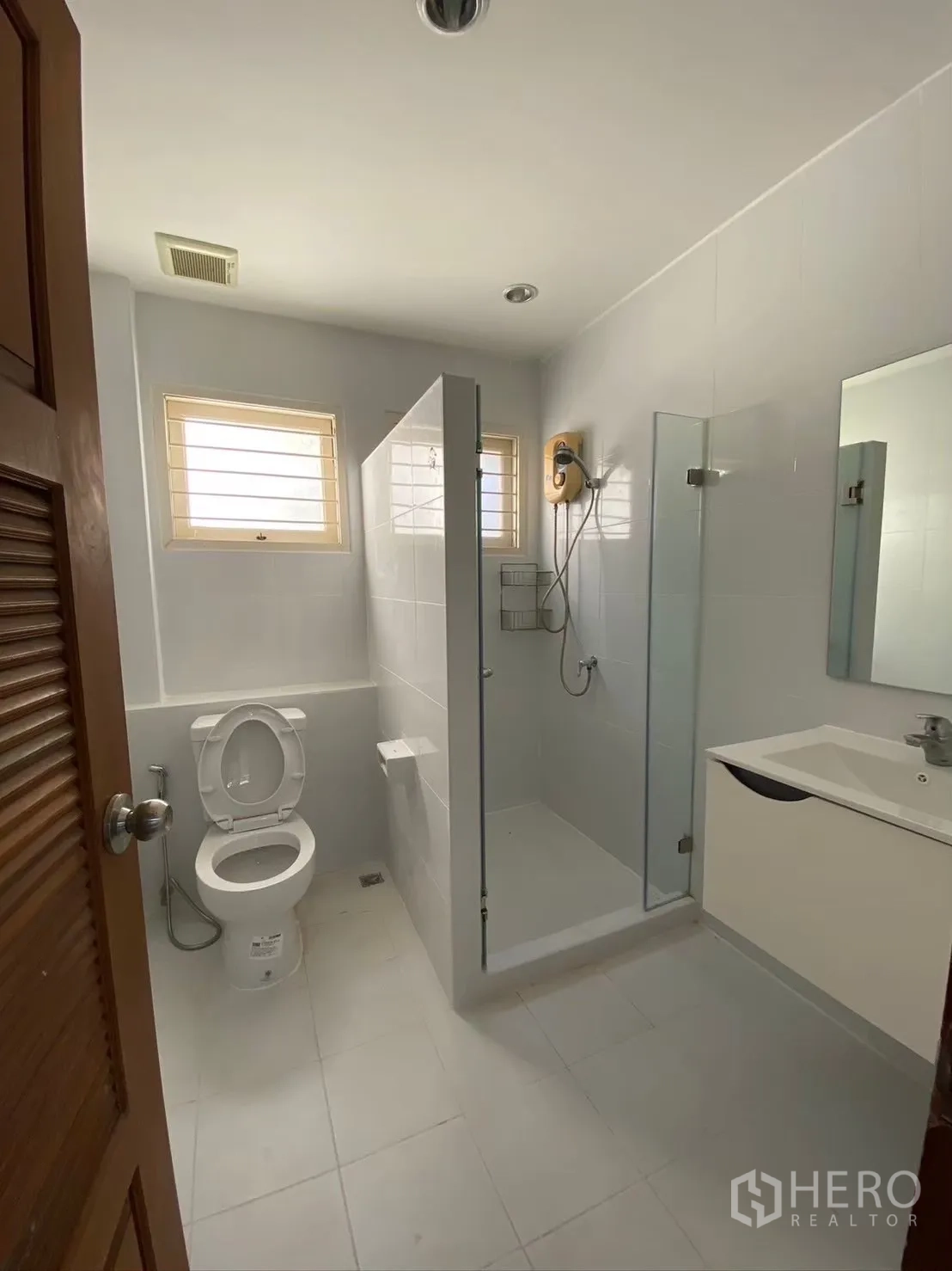 Detached House for rent in Watthana, Bangkok - Clean bathroom with shower enclosure, vanity and window ventilation.