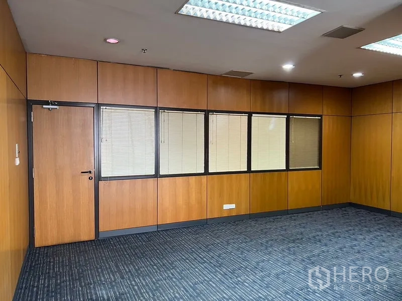 Office Space for rent - Carpeted office interior with wood-paneled walls, window blinds, and recessed ceiling lights.