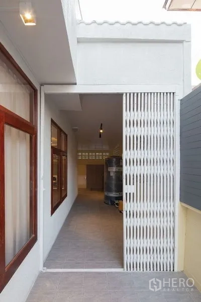 Detached House for sale in Chatuchak, Bangkok - Utility corridor with sliding security gate and water tank.