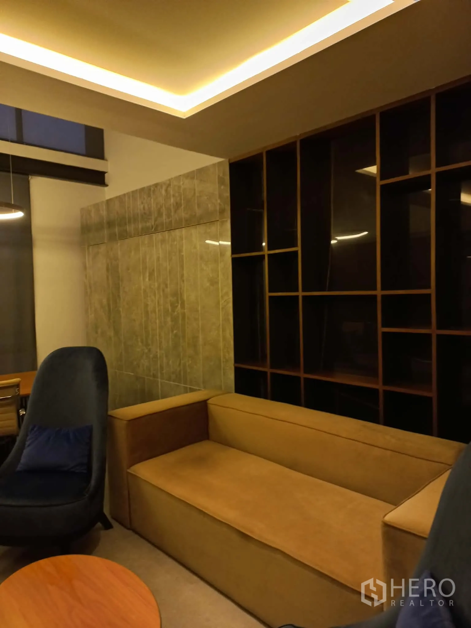 带办公室的家 for rent in Suan Luang, Bangkok - 温馨会客/会议角，设芥末色沙发与高背椅，大理石隔断和开放式书柜，灯光柔和。