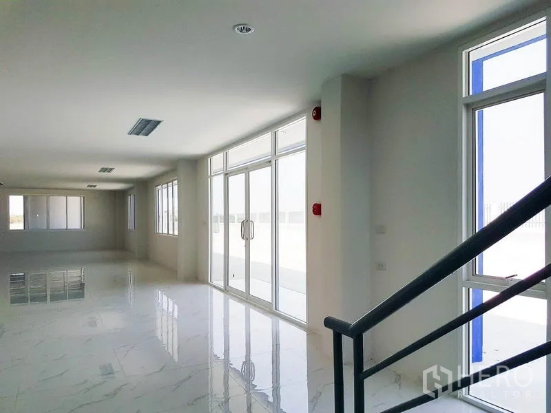 Warehouse for rent in Samut Prakan - Bright office lobby with glass doors and windows overlooking the loading yard.